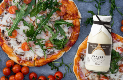 Pizza with truffle sauce, cherry tomatoes, arugula and prosciutto